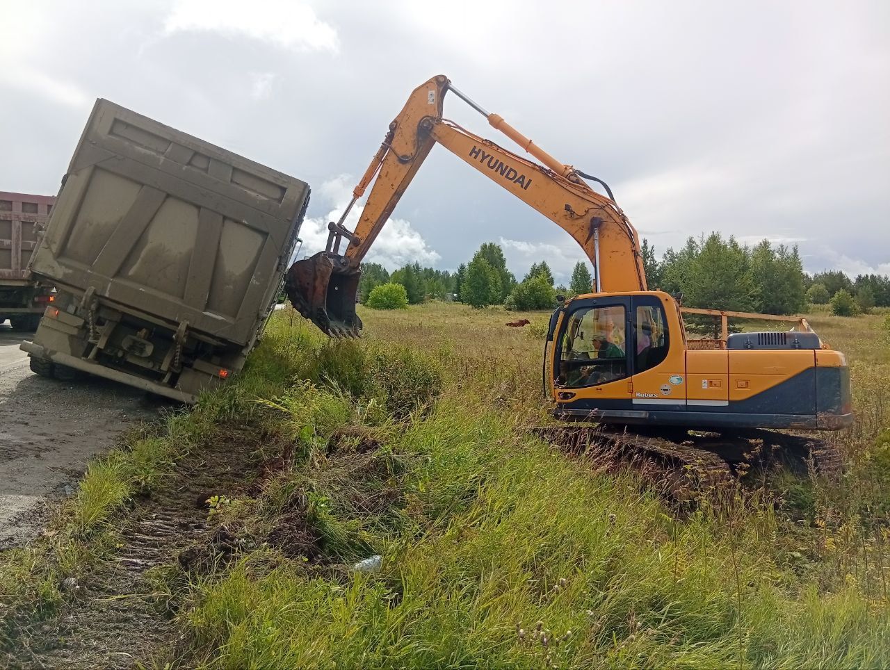 Груженный породой самосвал свалился на обочину в районе Кальи. Поднимали ковшом экскаватора 