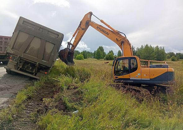 Груженный породой самосвал свалился на обочину в районе Кальи. Поднимали ковшом экскаватора 