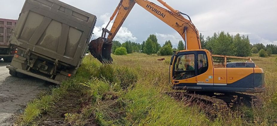 Груженный породой самосвал свалился на обочину в районе Кальи. Поднимали ковшом экскаватора 