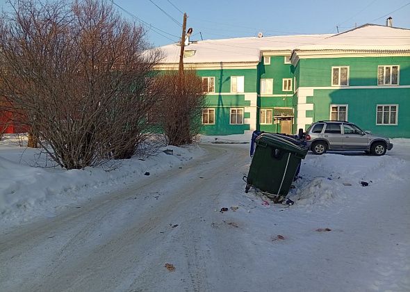 Контейнеры рядом с типографией стоят прямо на тротуаре. Люди обходят, мусор летит